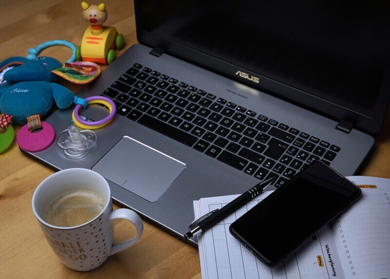 Laptop workspace with coffee and phone